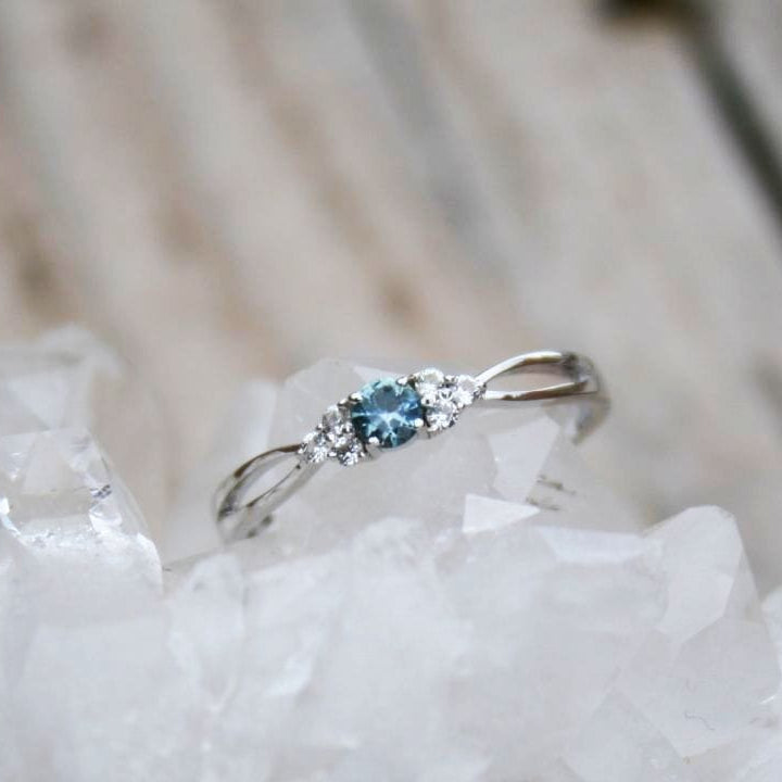 Blue Montana sapphire with white sapphire accents in dainty ring. 