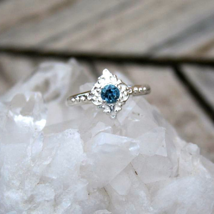 Blue sapphire ring with a filigree diamond shaped frame
