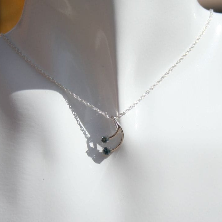 Silver necklace with dark sapphires on a mannequin