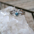Unique twig-style ring with blue gemstone on quartz crystal.