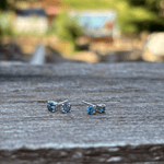 A pair of small stud earrings with round blue Montana sapphires set in sterling silver with butterfly backs.